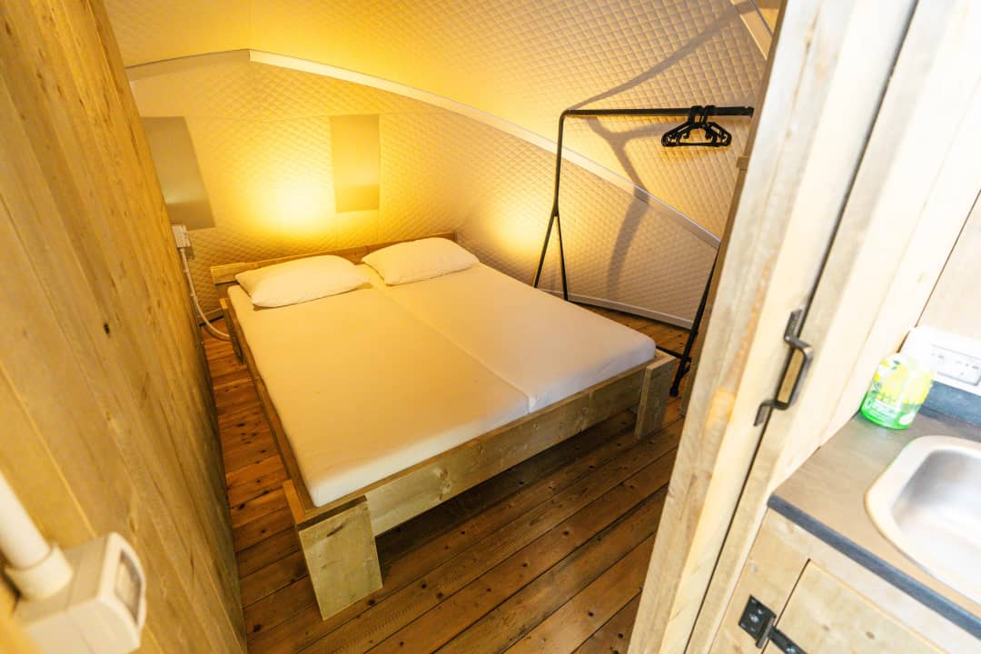 Camera da letto con letto matrimoniale e pareti in legno