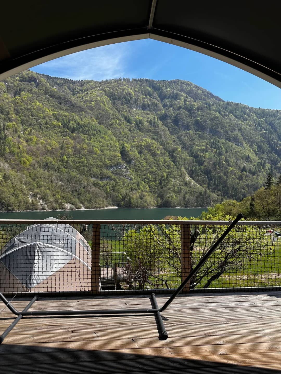 Vista dal portico coperto del Big Oak Lodge XL sul lago e sui pendii boscosi delle montagne