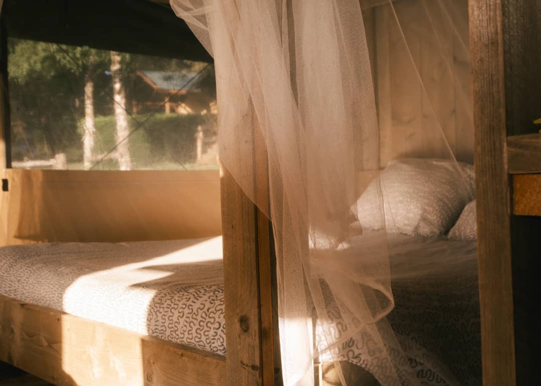 Il letto dietro la zanzariera nella luce del mattino