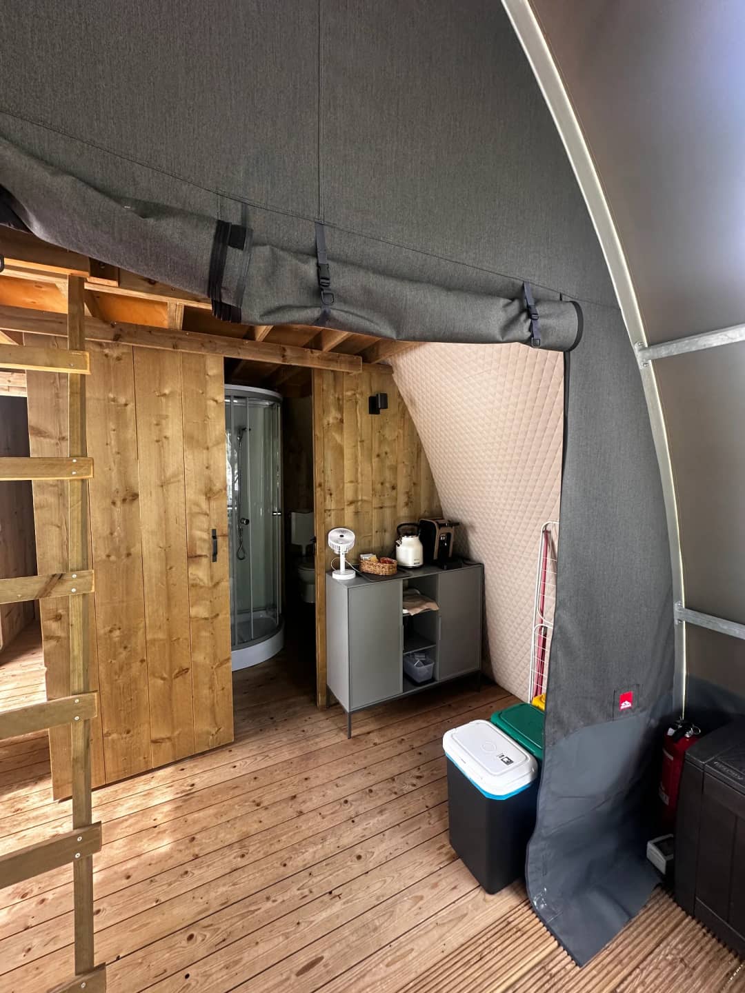All'interno del Big Oak Lodge XL: porta in legno che conduce al box doccia e un mobiletto con bollitore e tostapane