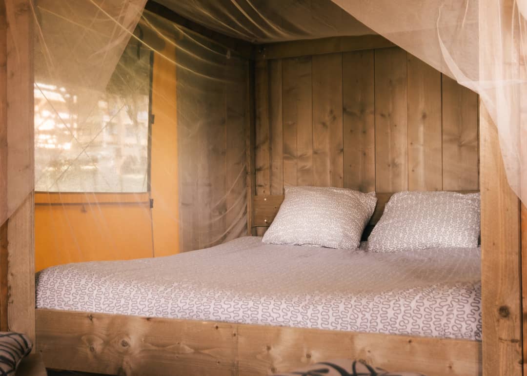 Letto matrimoniale nel Base Lodge con parete in legno